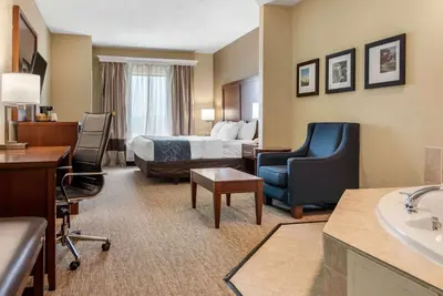 a hotel room with a bed and a bathroom at Comfort Suites Dayton-Wright Patterson in Dayton