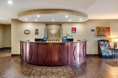 a hotel lobby with a large wooden reception desk at Comfort Suites Dayton-Wright Patterson in Dayton