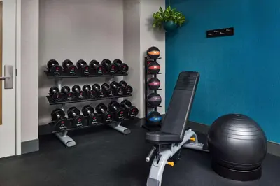a gym with a rack of dumbbells and a treadmill at Hampton Inn Massillon in Massillon