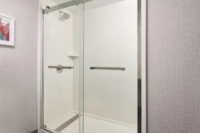 a shower with a glass door in a bathroom at Hampton Inn Massillon in Massillon