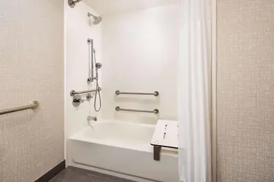 a white bathroom with a tub and a shower at Hampton Inn Massillon in Massillon