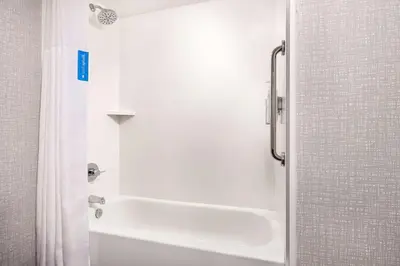a white bathroom with a shower and a tub at Hampton Inn Massillon in Massillon