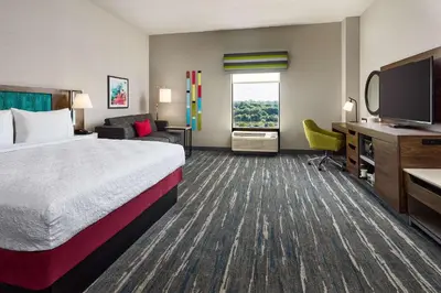 a hotel room with a bed and a flat screen tv at Hampton Inn Massillon in Massillon