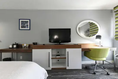 a bedroom with a desk with a television and a bed at Hampton Inn Youngstown-North in Youngstown
