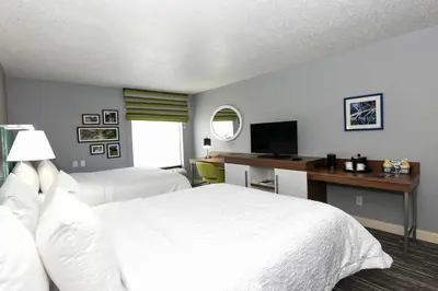 a hotel room with two beds and a desk with a television at Hampton Inn Youngstown-North in Youngstown
