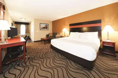 a hotel room with a large bed and a desk at La Quinta Inn by Wyndham Sandusky near Cedar Point in Sandusky