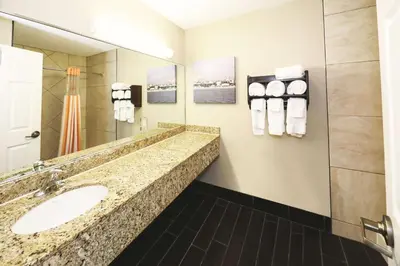 a bathroom with a sink and a mirror and towels at La Quinta Inn by Wyndham Sandusky near Cedar Point in Sandusky