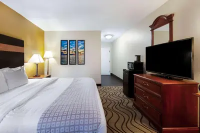 a hotel room with a bed and a flat screen tv at La Quinta Inn by Wyndham Sandusky near Cedar Point in Sandusky