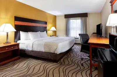 a hotel room with a large bed and a desk at La Quinta Inn by Wyndham Sandusky near Cedar Point in Sandusky