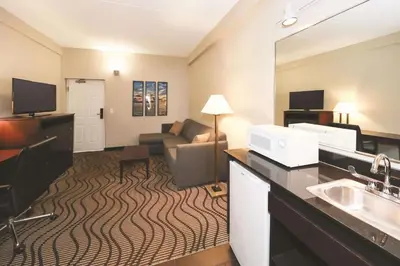 a hotel room with a sink and a living room at La Quinta Inn by Wyndham Sandusky near Cedar Point in Sandusky