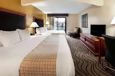 a hotel room with two beds and a television at La Quinta Inn by Wyndham Sandusky near Cedar Point in Sandusky