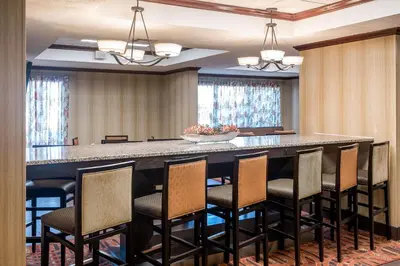 a conference room with a large bar with chairs at Hampton Inn Parkersburg/Mineral Wells in Mineralwells