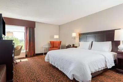a hotel room with a large bed and a television at Hampton Inn Parkersburg/Mineral Wells in Mineralwells