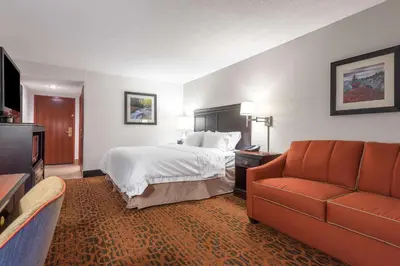 a hotel room with a bed and a couch at Hampton Inn Parkersburg/Mineral Wells in Mineralwells