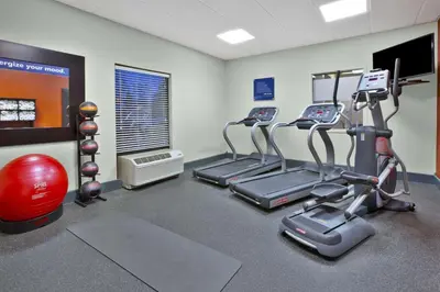 a gym with three tread machines and a red ball at Hampton Inn & Suites Springboro in Springboro