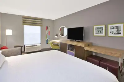 a hotel room with a bed and a desk with a television at Hampton Inn & Suites Springboro in Springboro