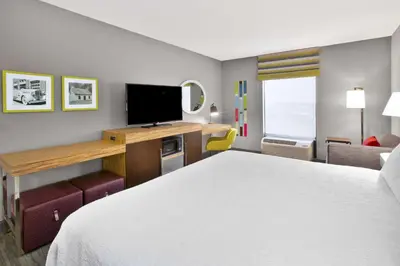 a hotel room with a bed and a desk with a television at Hampton Inn & Suites Springboro in Springboro