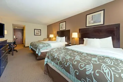 a hotel room with two beds and a flat screen tv at Wingate by Wyndham Erlanger - Florence - Cincinnati South in Erlanger