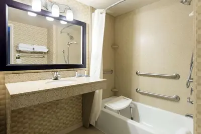 a bathroom with a sink and a tub and a mirror at Wingate by Wyndham Erlanger - Florence - Cincinnati South in Erlanger