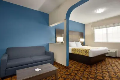 a hotel room with a bed and a couch at Baymont by Wyndham Winchester in Winchester