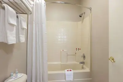 a bathroom with a shower and a tub and a toilet at Baymont by Wyndham Winchester in Winchester