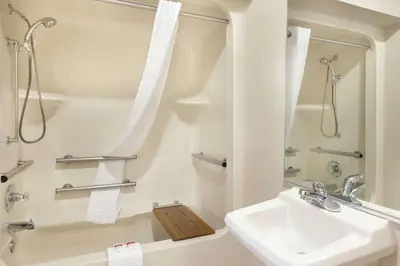 a white bathroom with a sink and a shower at Baymont by Wyndham Winchester in Winchester