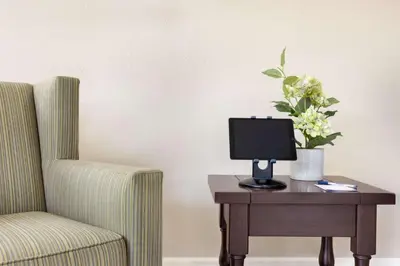 a chair and a computer on a table with a vase of flowers at Baymont by Wyndham Winchester in Winchester