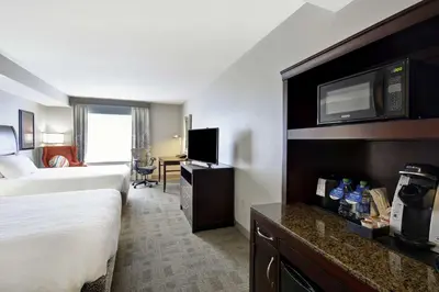 a hotel room with a bed and a flat screen tv at Hilton Garden Inn Toledo / Perrysburg in Perrysburg