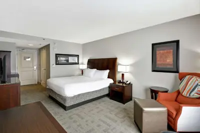 a hotel room with a bed and a living room at Hilton Garden Inn Toledo / Perrysburg in Perrysburg