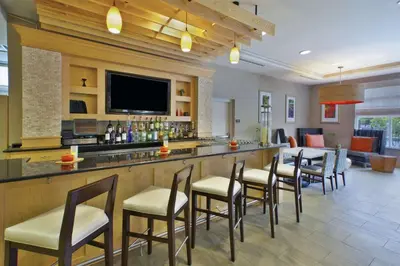 a bar in a hotel with chairs and a television at Hilton Garden Inn Toledo / Perrysburg in Perrysburg