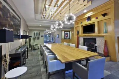 a dining room with a table and chairs and a fireplace at Hilton Garden Inn Toledo / Perrysburg in Perrysburg