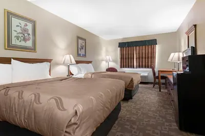 a hotel room with two beds and a desk at Quality Inn Washington Court House in Jeffersonville