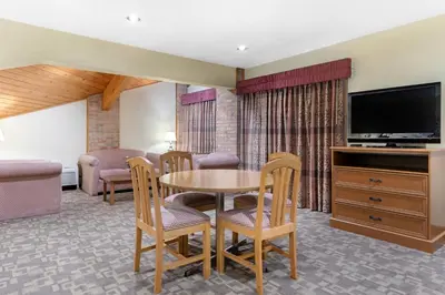 a living room with a table and chairs and a television at Quality Inn Washington Court House in Jeffersonville