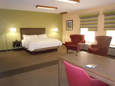 a hotel room with a bed and a table and chairs at Hampton Inn Shelbyville in Shelbyville
