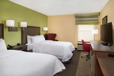 a hotel room with two beds and a flat screen tv at Hampton Inn Shelbyville in Shelbyville