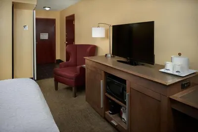 a hotel room with a television and a chair at Hampton Inn Shelbyville in Shelbyville