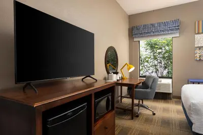 a living room with a large flat screen tv on a desk at Hampton Inn Carrollton KY in Carrollton