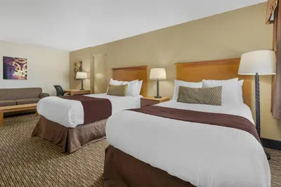 a hotel room with two beds and a couch at Best Western Winchester Hotel in Winchester