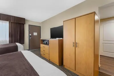 a hotel room with a bed and a flat screen tv at Best Western Winchester Hotel in Winchester