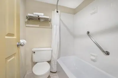 a white bathroom with a toilet and a bath tub at Best Western Winchester Hotel in Winchester