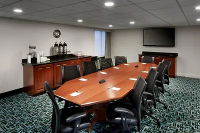 a conference room with a large wooden table and chairs at Wingate by Wyndham St. Clairsville/Wheeling in Saint Clairsville
