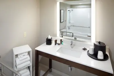 a bathroom with a sink and a large mirror at Wingate by Wyndham St. Clairsville/Wheeling in Saint Clairsville