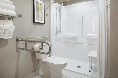 a white bathroom with a toilet and a shower at Wingate by Wyndham St. Clairsville/Wheeling in Saint Clairsville