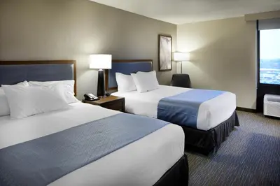 a hotel room with two beds and a window at Wingate by Wyndham St. Clairsville/Wheeling in Saint Clairsville