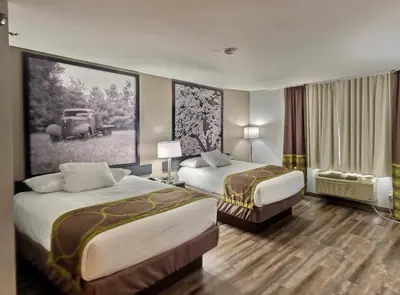a hotel room with two beds and a picture of a car at Super 8 by Wyndham Georgetown in Georgetown