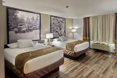 a hotel room with two beds and a picture of a car at Super 8 by Wyndham Georgetown in Georgetown