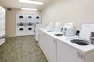 a laundry room with white washers and dryers at WoodSpring Suites Cincinnati Fairfield in Fairfield
