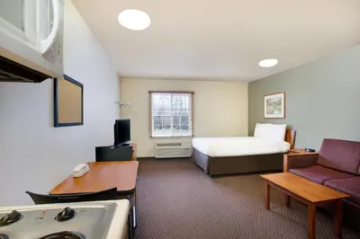 a hotel room with a bed and a sink at WoodSpring Suites Cincinnati Fairfield in Fairfield