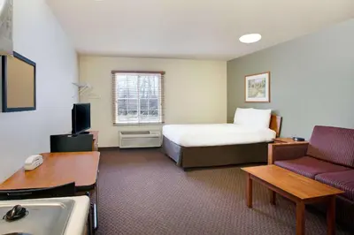 a hotel room with a bed and a couch at WoodSpring Suites Cincinnati Fairfield in Fairfield