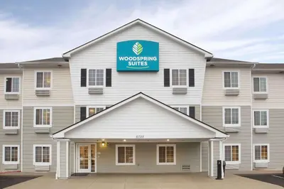 a building with a sign on top of it at WoodSpring Suites Cincinnati Fairfield in Fairfield